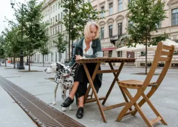 Elegant woman with Dalmatian dog sitting at an outdoor cafe in St. Petersburg, Russia.