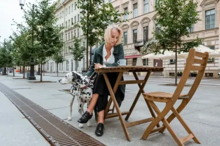 Elegant woman with Dalmatian dog sitting at an outdoor cafe in St. Petersburg, Russia.