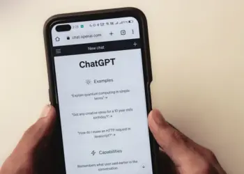 Close-up of hands holding a smartphone displaying the ChatGPT application interface on the screen.