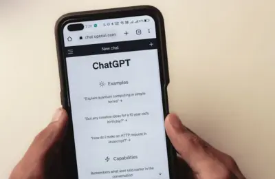 Close-up of hands holding a smartphone displaying the ChatGPT application interface on the screen.