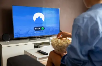 A relaxed scene at home with a person enjoying popcorn while watching a VPN-protected TV.