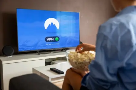 Como privar o Twitter: Descubra passos fáceis e rápidos! A relaxed scene at home with a person enjoying popcorn while watching a VPN-protected TV.