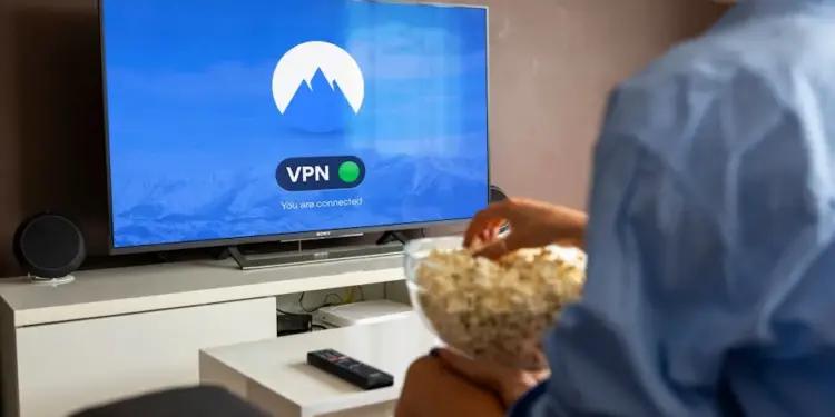 Como privar o Twitter: Descubra passos fáceis e rápidos! 1 A relaxed scene at home with a person enjoying popcorn while watching a VPN-protected TV.