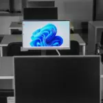 A contemporary office setup featuring computers on desks with modern flat screens.