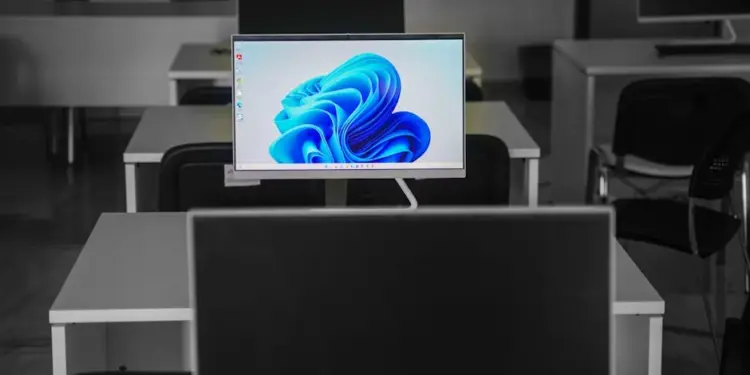 Como Saber Qual Meu Windows: Descubra em Poucos Passos! 1 A contemporary office setup featuring computers on desks with modern flat screens.