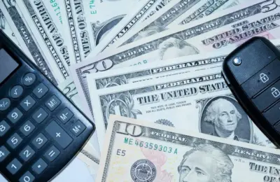 US dollars, calculator, and car keys representing finance and investment tools.