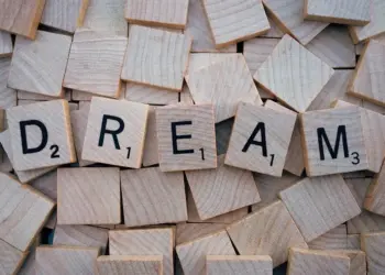 Idade Mental: O Que Isso Revela Sobre Você Em 2026! 9 Close-up of wooden Scrabble tiles spelling the word 'DREAM', symbolizing creativity and imagination.