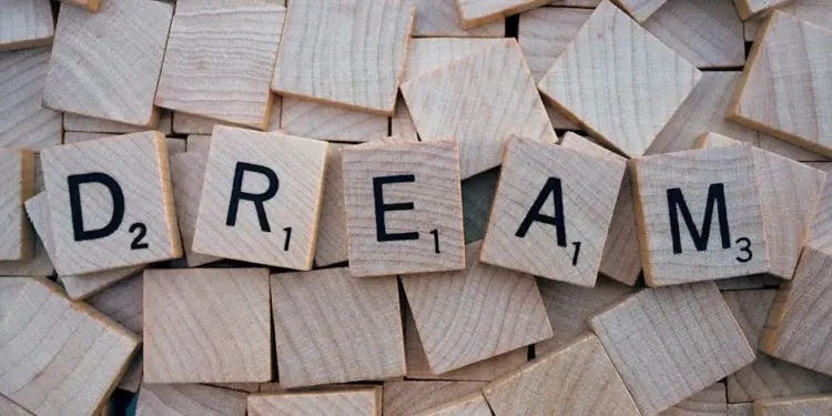 Idade Mental: O Que Isso Revela Sobre Você Em 2026! 1 Close-up of wooden Scrabble tiles spelling the word 'DREAM', symbolizing creativity and imagination.