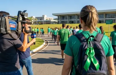 Pessoas vistas de costas caminhando pelo campus da UFJF vestindo camisetas verdes em apoio à campanha de segurança do trabalho Abril Verde ufjf.